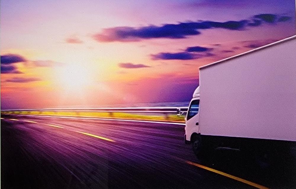 Ultimate Logistics truck on the highway at sunset